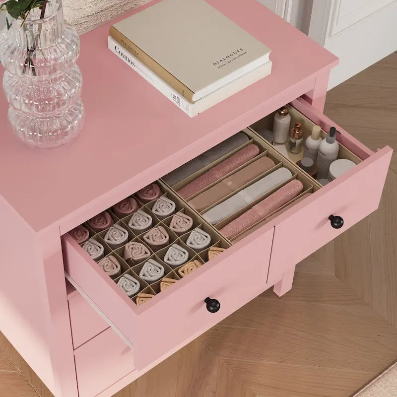 Commode en bois rose avec 4 tiroirs et boutons noirs
